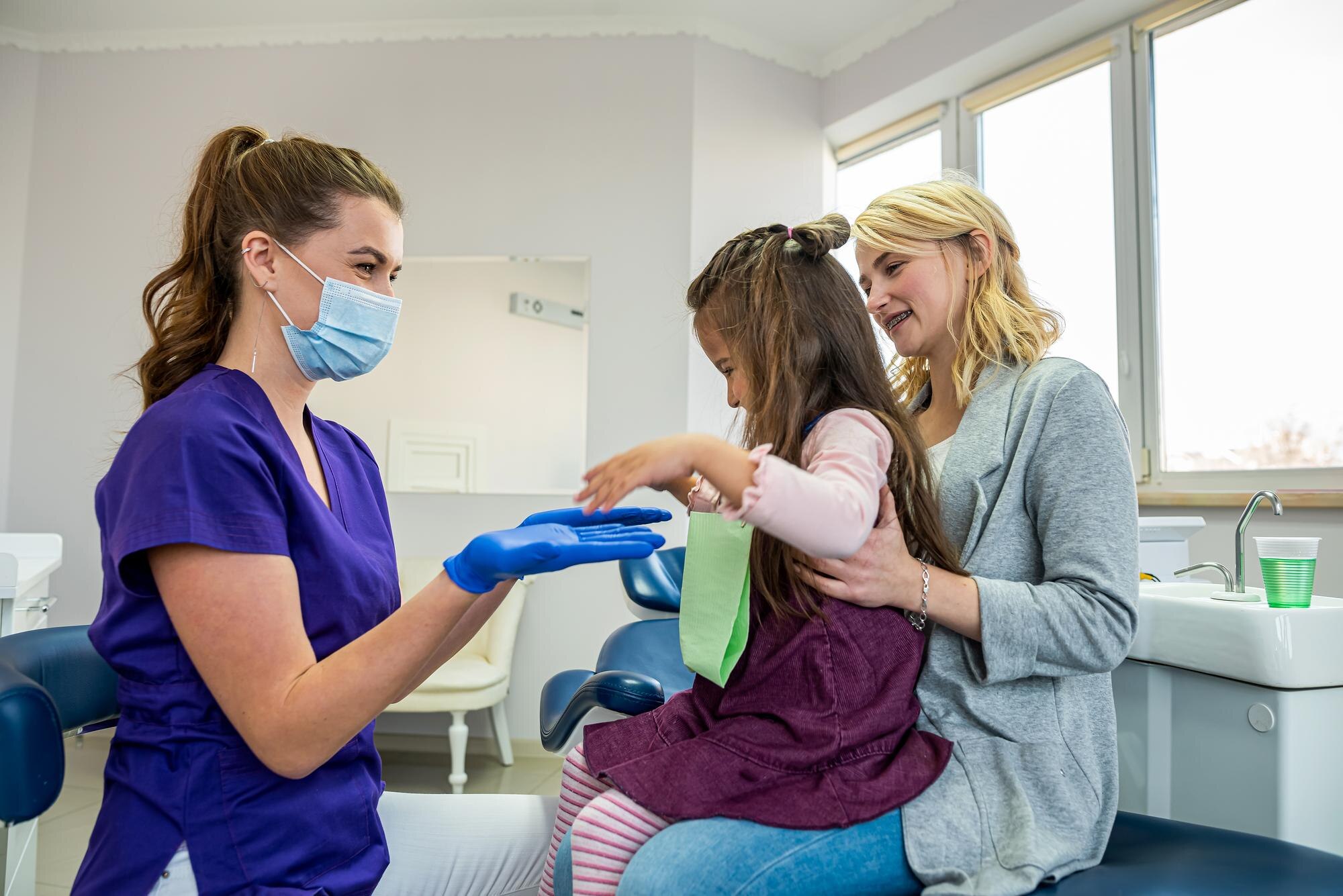 dentium clinica dental - Servicios - mom child visit their pediatric dentist doctor talking with patient